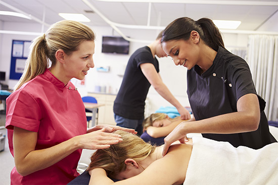 Massage instructor helping massage student